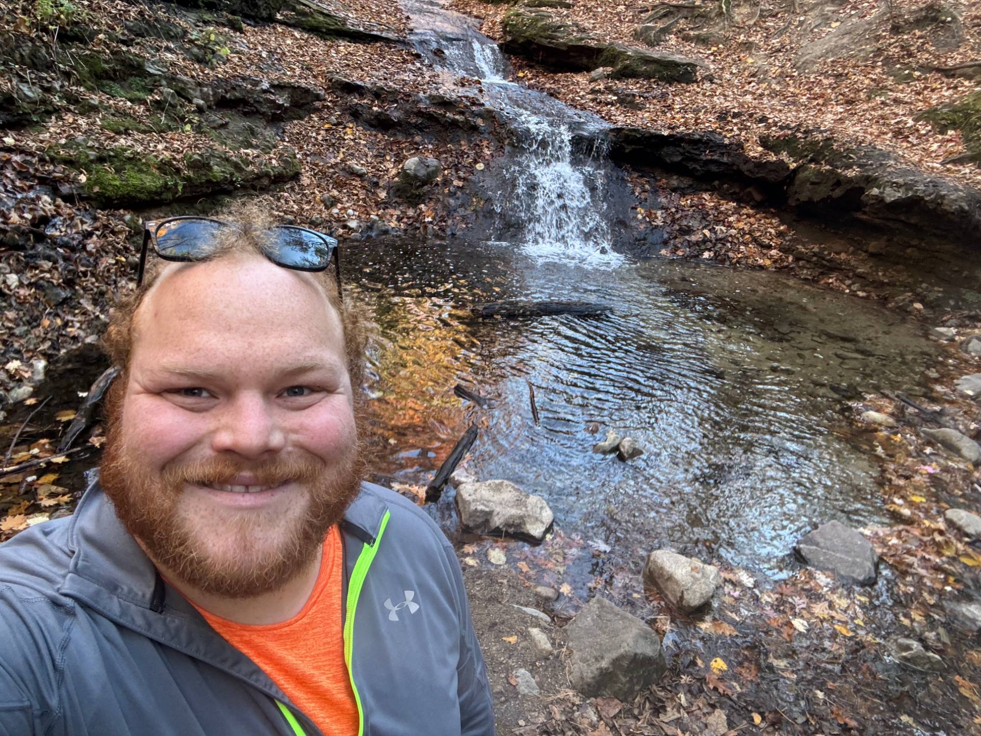 Man smiling next to a stream